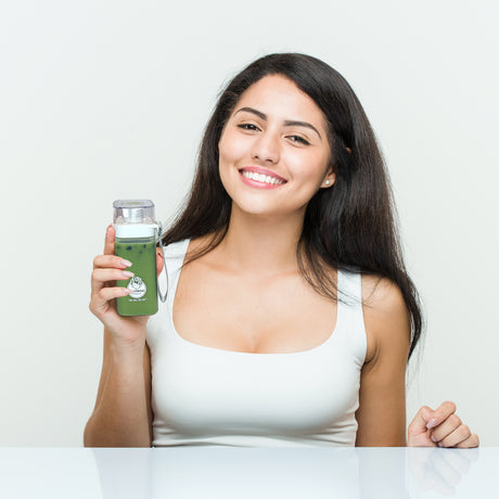 woman holding a NUTRIBOBA ceremonial matcha moringa tea latte